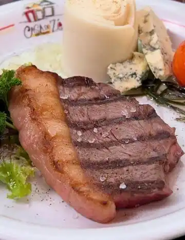 Bife grelhado com acompanhamentos variados.