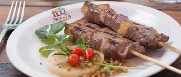 Espetinhos de carne com acompanhamento.
