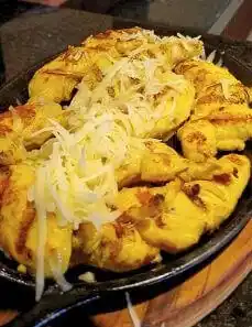 Prato de peito de frango com cebolas.