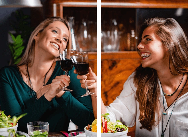 Duas mulheres brindando com ta&ccedil;as de vinho.
